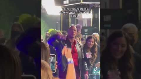 The Rock sings his song along with fans at the red carpet