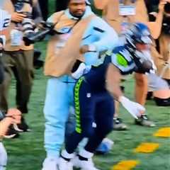 Marshawn Lynch stiff arms player to protect his camera during Seahawks preseason game in wild scene