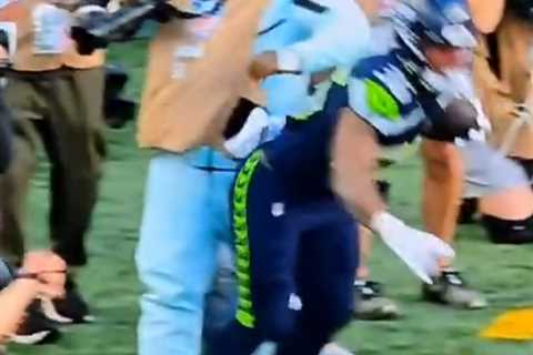 Marshawn Lynch stiff arms player to protect his camera during Seahawks preseason game in wild scene